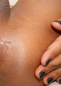 Manaw is dressed in a tight silver top and matching little booty shorts hugging her all natural, curvy body.